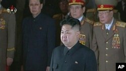 New North Korean ruler Kim Jong Un (front) pays his respects to his father and former leader Kim Jong Il, lying in state at the Kumsusan Memorial Palace in Pyongyang, December 20, 2011.
