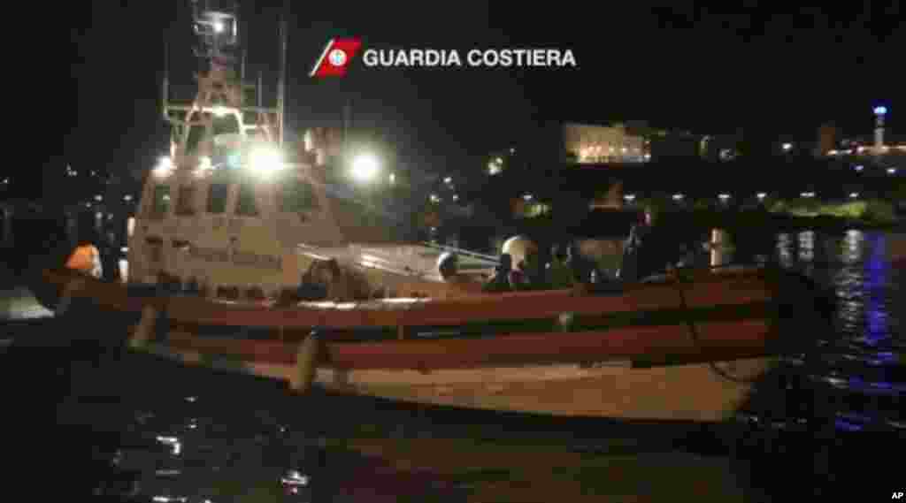 This image from video shows survivors of a ship that sank being transported on an Italian Coast Guard vessel as it arrives at port, Lampedusa, Italy, Oct. 3, 2013. (Italian Coast Guard)
