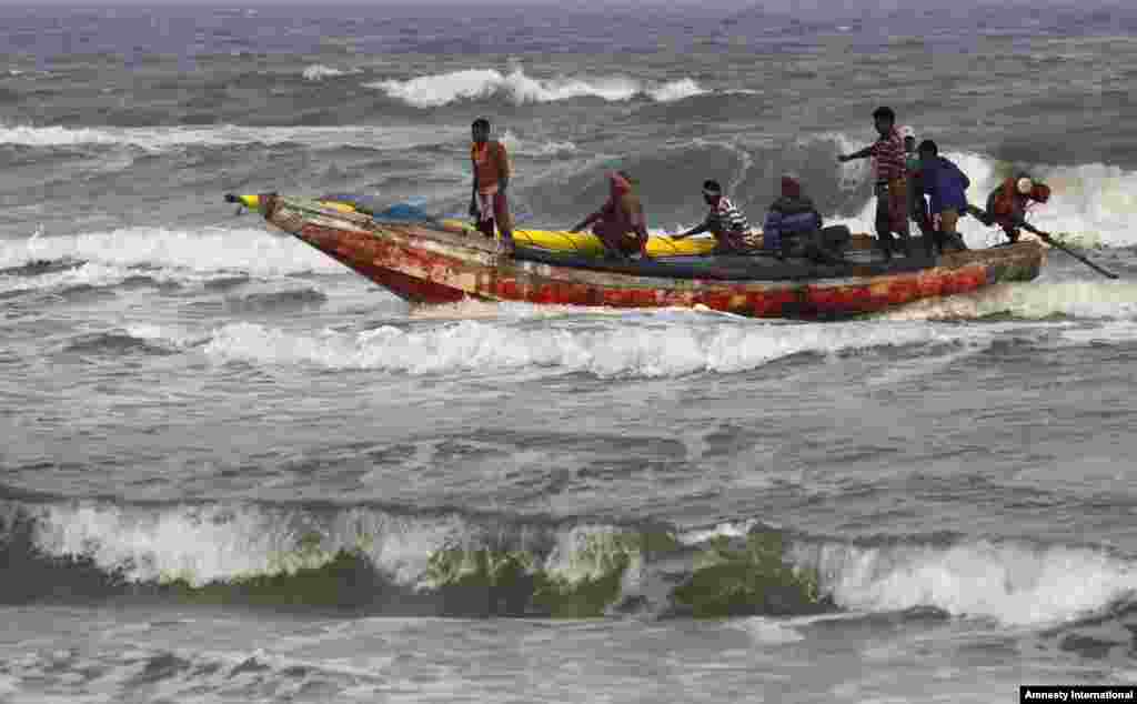 Indian fishermen return to shore after a cyclone alert was sounded in the coastal area of Gopalpur, in the eastern Indian state of Orissa, Nov. 27, 2013.