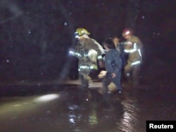 Emergency personnel rescue people from flood waters and debris after a mudslide in Montecito, California, U.S. in this photo provided by the Santa Barbara County Fire Department, Jan. 9, 2018.