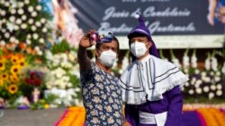 Dos hombres se toman una foto frente a la iglesia cerrada de la Candelaria durante la Semana Santa en la Ciudad de Guatemala.