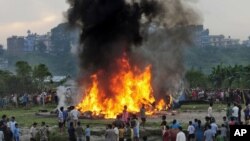Nepalese gather around the burning wreckage at the crash site of a Sita Air airplane near Katmandu, Nepal, September 28, 2012.