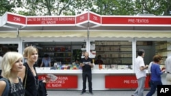 A man browses a book as other people walk by at a book fair in Madrid, Spain, May 28, 2010 (file photo)