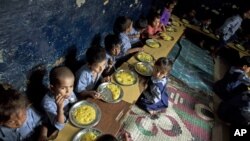 Children eat a meal at a school in a shanty neighborhood of New Delhi, India, Sept. 13, 2012.