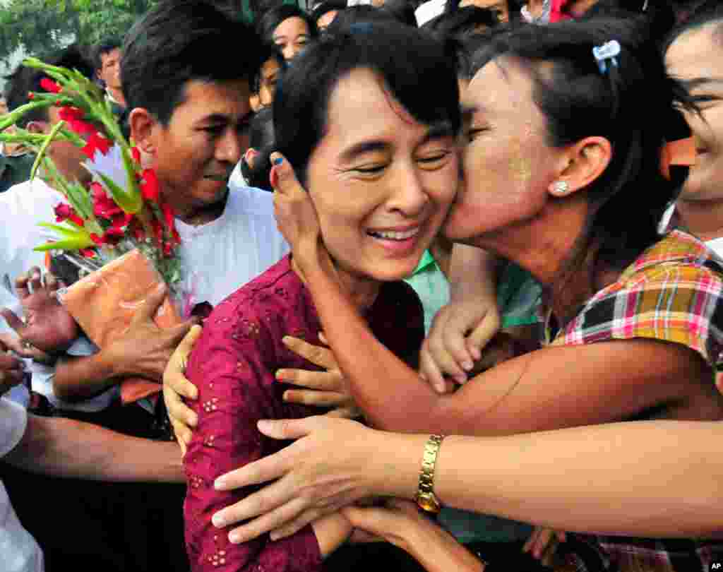 July 7: Myanmar democracy icon Aung San Suu Kyi is greeted as she visits Nyaung Oo market in Myanmar. Suu Kyi was visiting the village with her youngest son Kim Aris and members of the National League for Democracy party. (AP Photo/Khin Maung Win)