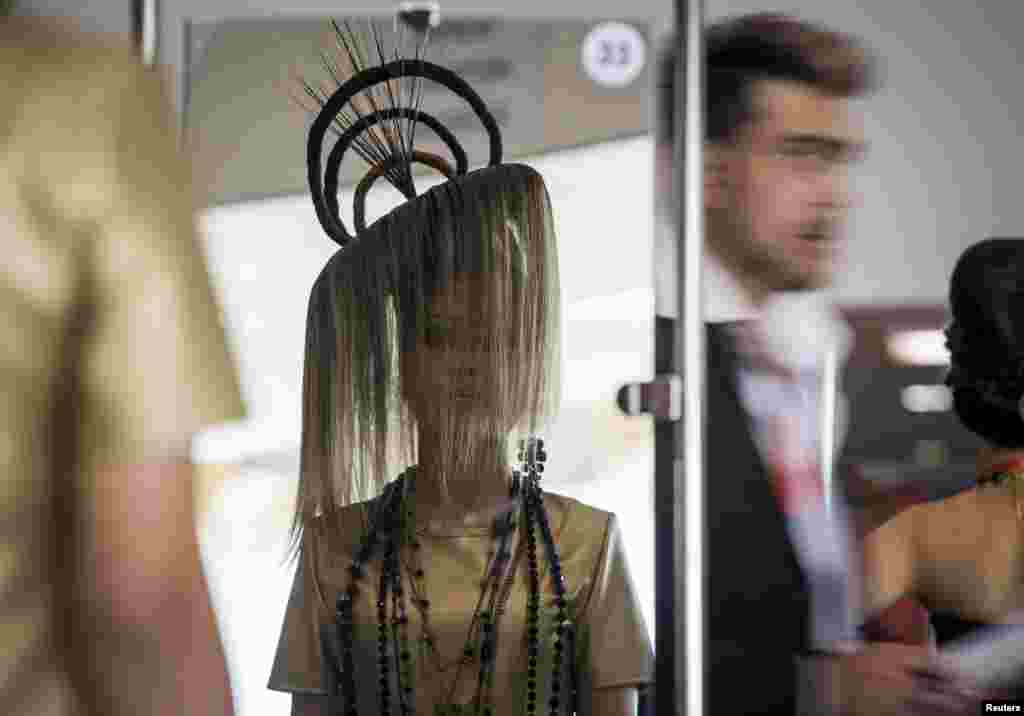 A model is reflected in a mirror as she presents a hairstyle during a national championship on hairdressing, nail esthetics, make-up and body art in Almaty, Kazakhstan.