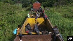 Des migrants du Honduras montent dans un train de marchandises en direction du nord, à Salto del Agua, au Mexique, le 25 juin 2019.