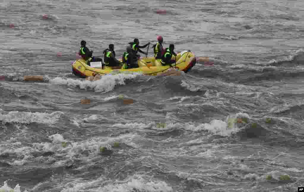 Rescue workers search the flooded River Savitri after an old bridge collapsed in Mahad, western Maharashtra state, India. Two buses plunged into the river after the old bridge collapsed, an official said.