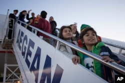 Refugees board an aircraft at Athens International airport, leaving Greece for Luxembourg, Nov. 4, 2015. It is the first such relocation from Greece under a new EU relocation plan but only a minuscule fraction of the hundreds of thousands who have entered