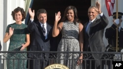 De izquierda a derecha, Agnese Landini esposa del primer ministro, Matteo Renzi, Michelle Obama, presidente Barack Obama saludan desde el balcón Truman de la Casa Blanca.
