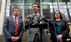Attorney General Bob Ferguson, center, stands with Solicitor General Noah Purcell, left, and Civil Rights Unit Chief Colleen Melody as he speaks with media members on the steps of the federal courthouse after an immigration hearing there, March 15, 2017,