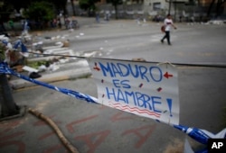 A sign that reads in Spanish: "Maduro is hunger!" forms part of a barricade made by demonstrators during a 48-hour general strike beginning July 26, 2017. In the capital, Caracas, many residents stayed home in observance of the strike.