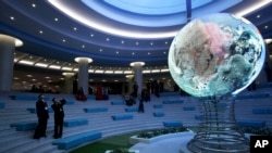 Seorang pengunjung memotret model iluminasi sebuah globe di Kompleks Sci-Tech, Pyongyang, Korea Utara (3/2). 