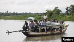 FILE - Rohingya Muslims travel on a boat along a river in Buthidaung township, Myanmar, June 7, 2015. A boat carrying more than 60 people capsized in rough waters off of Sittwe in Myanmar's Rakhine state Tuesday.