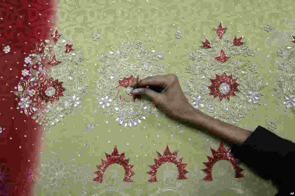 A Bangladeshi man works at an embroidery factory before Eid al-Fitr celebrations in Dhaka, Bangladesh, July 30, 2013.&nbsp;