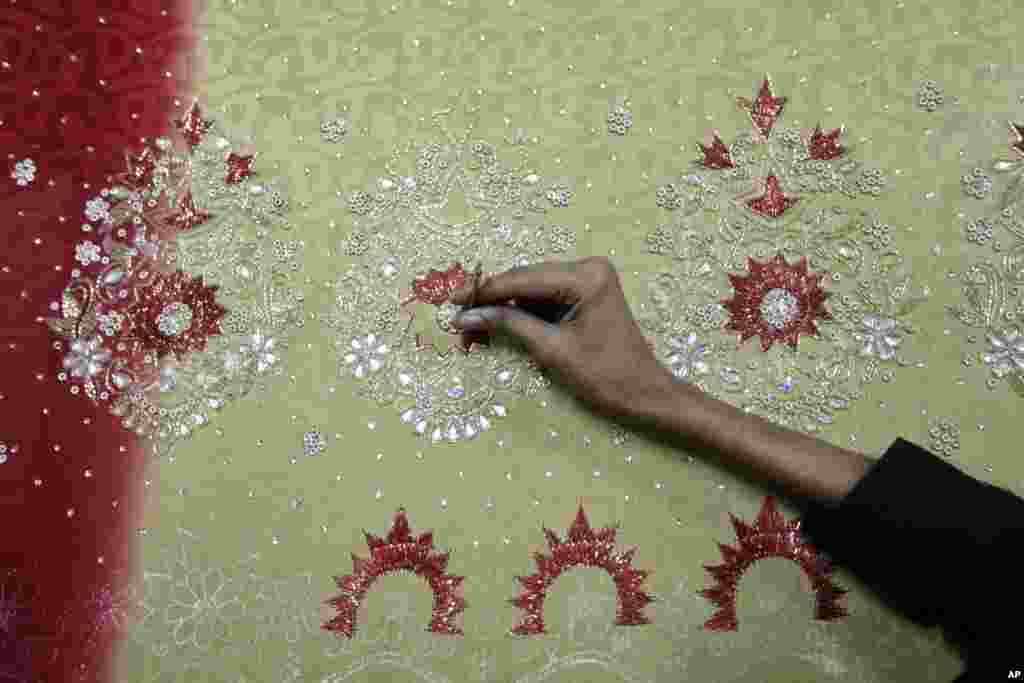 A Bangladeshi man works at an embroidery factory before Eid al-Fitr celebrations in Dhaka, Bangladesh, July 30, 2013. 