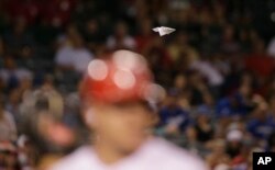 FILE - A paper airplane descends onto the field during the eighth inning of a baseball game between the Los Angeles Angels and the Los Angeles Dodgers, Sept. 8, 2015, in Anaheim, Calif.
