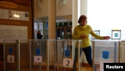 A member of a local electoral commission takes part in preparations for the upcoming presidential election at a polling station in Kyiv, Apr. 20, 2019. 