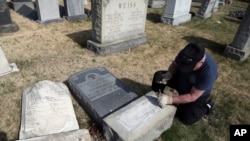 Bob se consacre volontairement à réparer la base d'une pierre tombale endommagée au cimetière juif de Philadelphie où une profanation a eu lieu, 28 février 2017. 