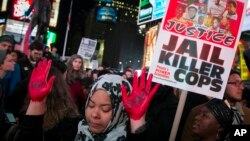 Manos rojas y en alto en una manifestación en Times Square, Nueva York.