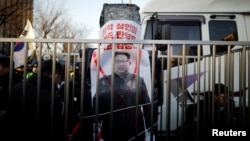 A banner with the image of North Korean leader Kim Jong Un is seen as members of a South Korean conservative civic group take part in an anti-North Korea protest in Seoul, South Korea, Dec. 8, 2018.
