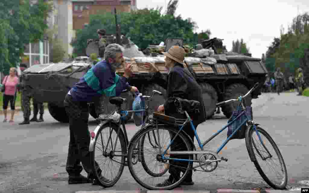 Local residents talk in front of an Ukrainian armored personnel carrier (APC) in the eastern Ukrainian city of Slavyansk.