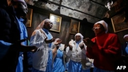 Christian pilgrims pray in the Grotto of the Church of the Nativity on Christmas Eve in the biblical West Bank city of Bethlehem on December 24, 2019.