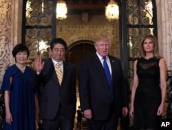 FILE - President Donald Trump and first lady Melania Trump stop to pose for a photo with Japanese Prime Minister Shinzo Abe, second from left, and his wife Akie Abe, left, before they have dinner at Mar-a-Lago in Palm Beach, Fla., Feb. 2017.