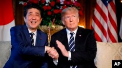 FILE - President Donald Trump and Japanese Prime Minister Shinzo Abe speak during a meeting at Trump's private Mar-a-Lago club, in Palm Beach, Florida, April 17, 2018.