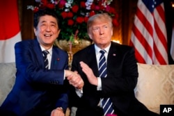 President Donald Trump and Japanese Prime Minister Shinzo Abe speak during a meeting at Trump's private Mar-a-Lago club, in Palm Beach, Fla.