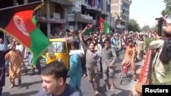 Warga melakukan protes anti-Taliban dengan membawa bendera nasional Afghanistan di Jalalabad, Kamis (19/8). 