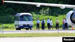 File Photo: Asylum seekers are pictured being transported from an aircraft to a bus upon their arrival on the island of Nauru, September 14, 2012. Australia has flooded Nauru with money since 2012, when the island became a key plank in its controversial policy of dealing with asylum seekers.