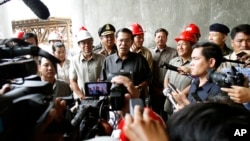 Cambodian Prime Minister Hun Sen, center, gives a press conference during his tour to an under construction bridge at Stung Mean Chey commune, file photo. 