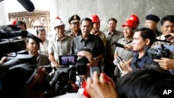 Cambodian Prime Minister Hun Sen, center, gives a press conference during his tour to an under construction bridge at Stung Mean Chey commune, in Phnom Penh, file photo. 