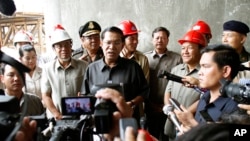 Cambodian Prime Minister Hun Sen, center, gives a press conference during his tour to an under construction bridge at Stung Mean Chey commune, in Phnom Penh, file photo. 
