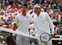 Novak Djokovic of Serbia, left, and Roger Federer of Switzerland pose for photographers before their men's singles final at the All England Lawn Tennis Championships in Wimbledon, London, Sunday July 6, 2014. (AP Photo/Ben Curtis)