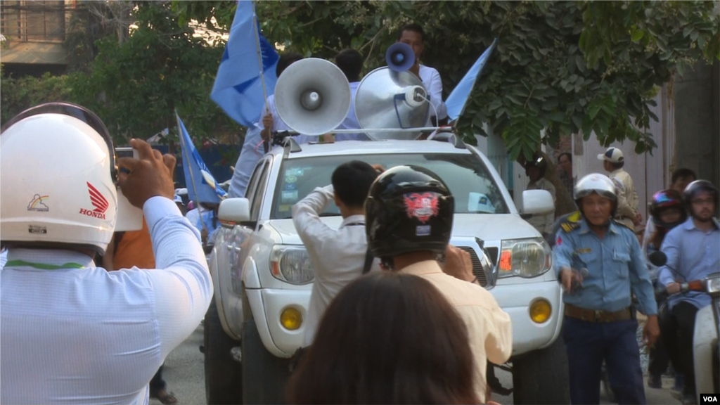 Traffic police officer facilitate the traffic for the demonstrators during the protest against CNRP&#39;s acting president, Kem Sokha. (Pin Sisovann/VOA Khmer)