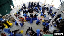 Migrants are seen on board the MV Aquarius, in the Mediterranean Sea, between Malta and Linosa, Aug. 14, 2018. 