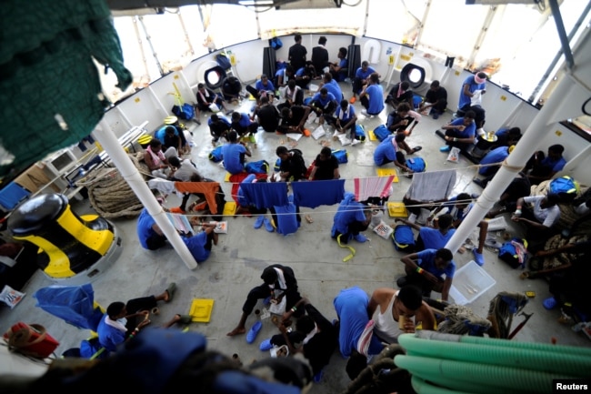 FILE - Migrants are seen on board the MV Aquarius, in the Mediterranean Sea, between Malta and Linosa, Aug. 14, 2018.