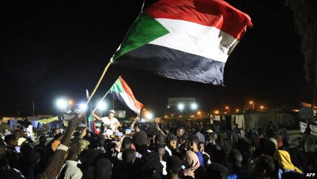 Sudanese protesters celebrate after an agreement was reached with the military council to form a three-year transition period for transferring power to a full civilian administration, in Khartoum, May 15, 2019.