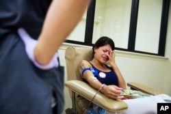 Tatiana Osorio of Orlando, Fla., cries while giving blood at the OneBlood center, near the nightclub where a mass shooting occurred the night before, June 13, 2016. Osorio lost three friends in the shooting.