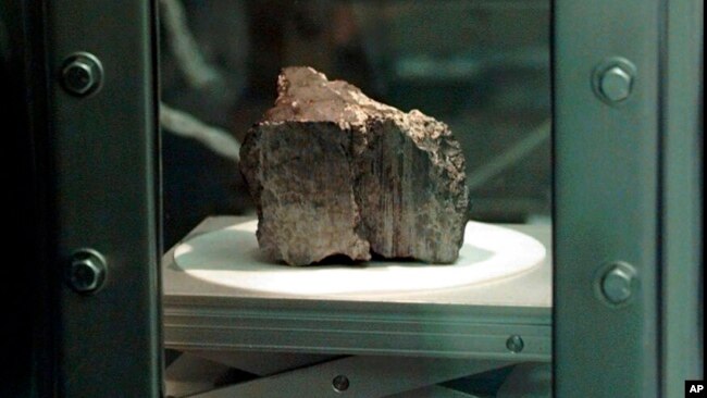 FILE - The meteorite labeled ALH84001 sits in a chamber at a Johnson Space Center lab in Houston, Aug. 7, 1996. Scientists say they've confirmed the meteorite from Mars contains no evidence of ancient Martian life.