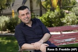 Iraqi born refugee Bilal Alobaidi and new U.S. citizen, poses for a photo Friday, Sept. 4, 2020, in Phoenix, (AP Photo/Ross D. Franklin)