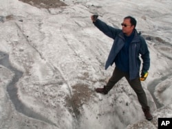 This Sept. 22, 2018 photo shows glaciologist Wang Shijin photographing an ice crevasse in the Baishui Glacier No. 1 on the Jade Dragon Snow Mountain in the southern province of Yunnan in China.