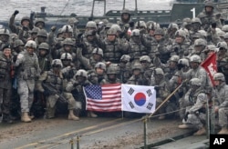 FILE - U.S. and South Korean army soldiers pose on a floating bridge on the Hantan river during a joint military exercise against a possible attack from North Korea, in Yeoncheon, South Korea, Dec. 10, 2015.