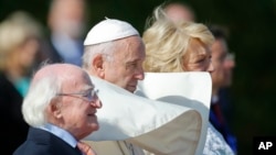 Pope Francis, center, is flanked by Irish President Michael D. Higgins, left, and President's wife Sabina, upon his arrival at the Presidential residence in Dublin, Ireland, Aug. 25, 2018. 