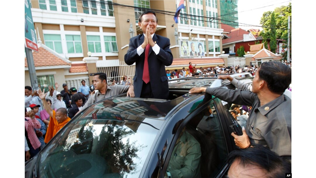 FILE - Cambodia's main opposition Cambodia National Rescue Party Deputy President and National Assembly Deputy President Kem Sokha greets to his supporters outside the Phnom Penh Municipality Court in Phnom Penh, Wednesday, April 8, 2015.