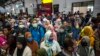 Para penumpang kereta api mengenakan masker sebagai pencegahan virus corona, di stasiun di Surabaya, 15 Maret 2020. (Foto: AFP)