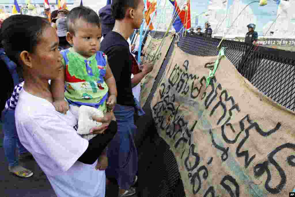 Supporters gather in front of banners that read &quot;Please provide justice to land activists of Boeung Kak&quot; at a congested street near Phnom Penh Municipality Court in Phnom Penh, Cambodia, May 30, 2014.