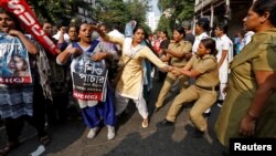 FILE - A police woman tries to detain an activist of Socialist Unity Centre of India (SUCI) during a protest against the trafficking of children, in Kolkata, India, Nov. 29, 2016.